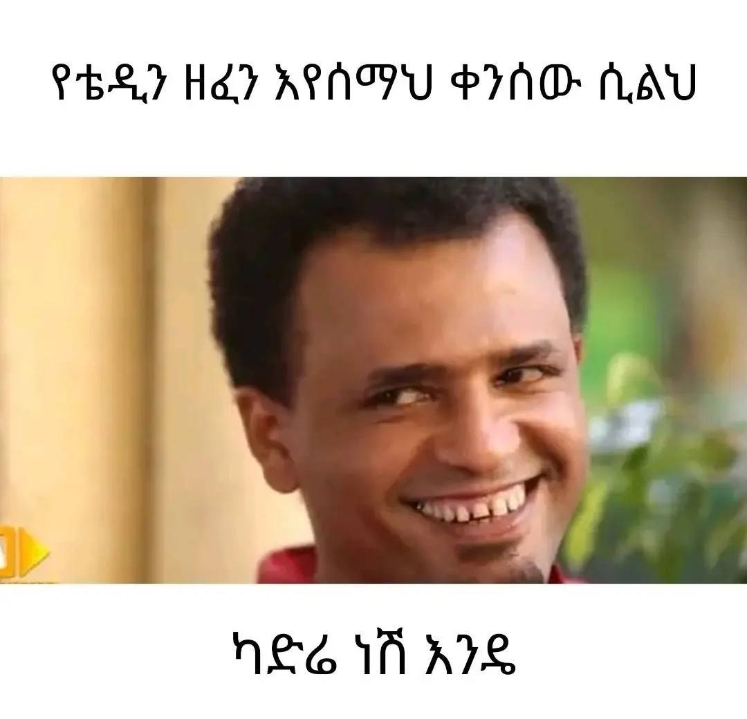 a man smiling and wearing a red shirt